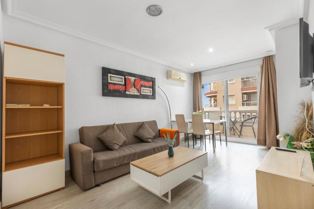 una sala de estar con un sofá y una mesa en Homely Apartments Las Salinas, en Torrevieja