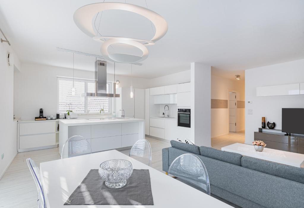 a living room and kitchen with a couch and a table at SWEETHOME TALVERA - con Garage in Bolzano