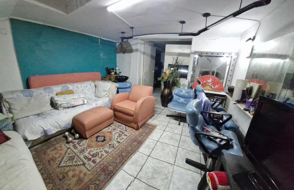 ein Wohnzimmer mit einem Bett und einem Spiegel in der Unterkunft Residencia familiar in São Paulo