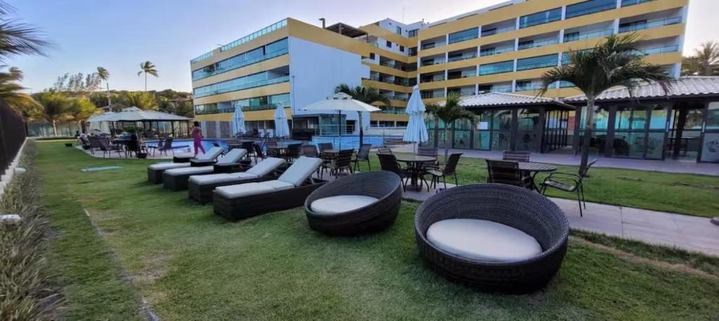 a row of black chairs and tables and a building at Flat beiramar praia de Tabatinga in Conde