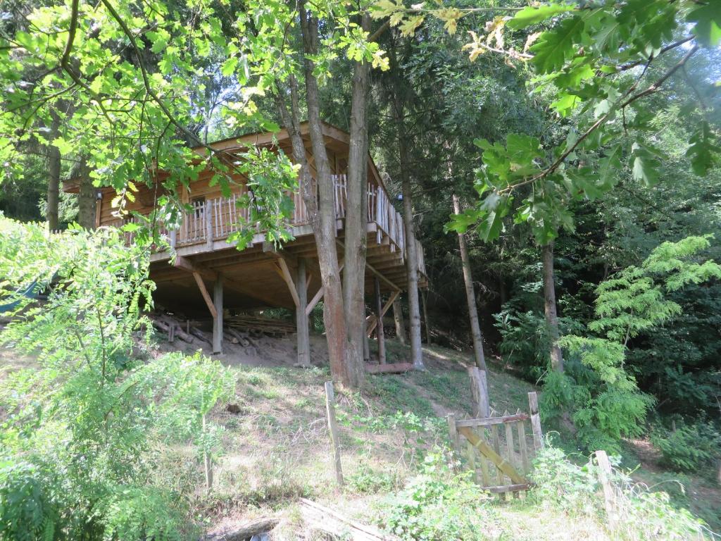 a tree house in the middle of the woods at La Cabane aux Sapins in Ratières