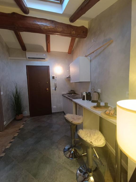 a kitchen with a counter and stools in a room at La Mansardina di Sabrina in Busca