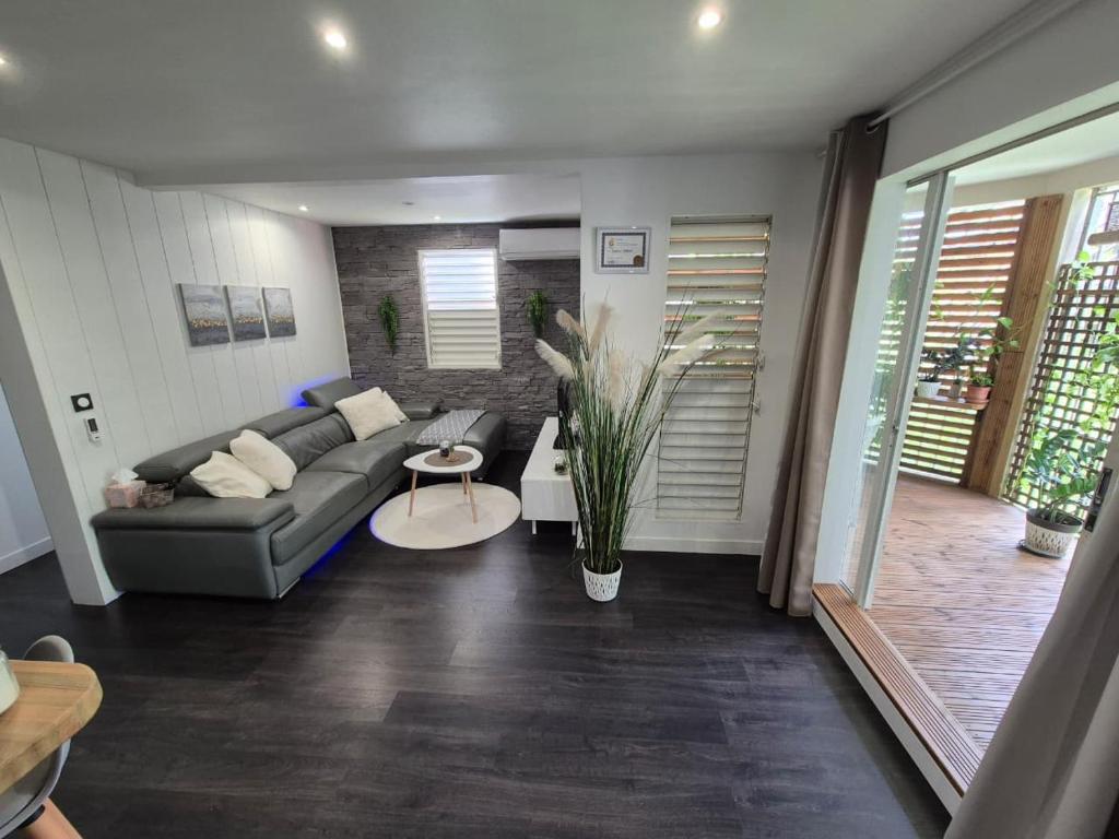 a living room with a couch and a table at Sensalys in Sainte-Rose