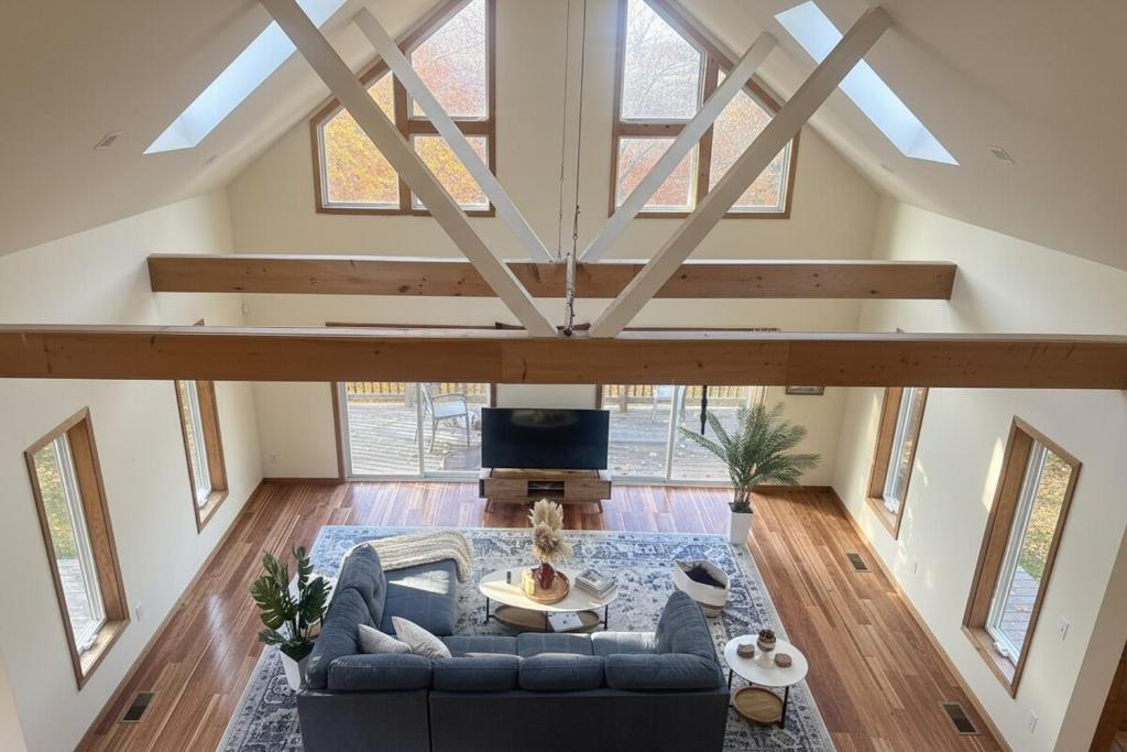 an attic living room with a blue couch and a table at Blue Bird Chalet 5BR with Sauna near Skiing in East Chatham