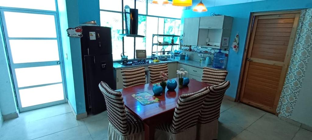 a kitchen with a table with chairs and a refrigerator at Casa San Ramón in San Ramón