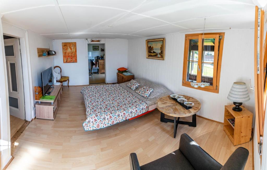 a living room with a bed and a table at Romantic Alpine Farmhouse with Superview of Lake Near Interlaken in Sundlauenen