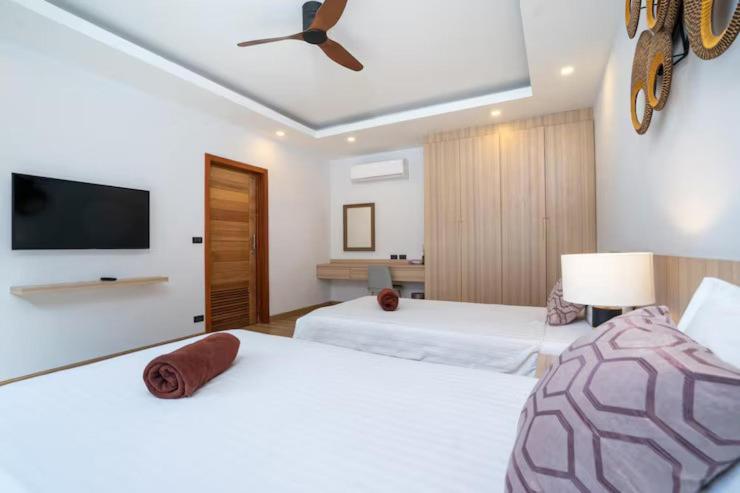 Un dormitorio con dos camas y un televisor de pantalla plana. en Hostal Colonial Dominicano, en Santo Domingo