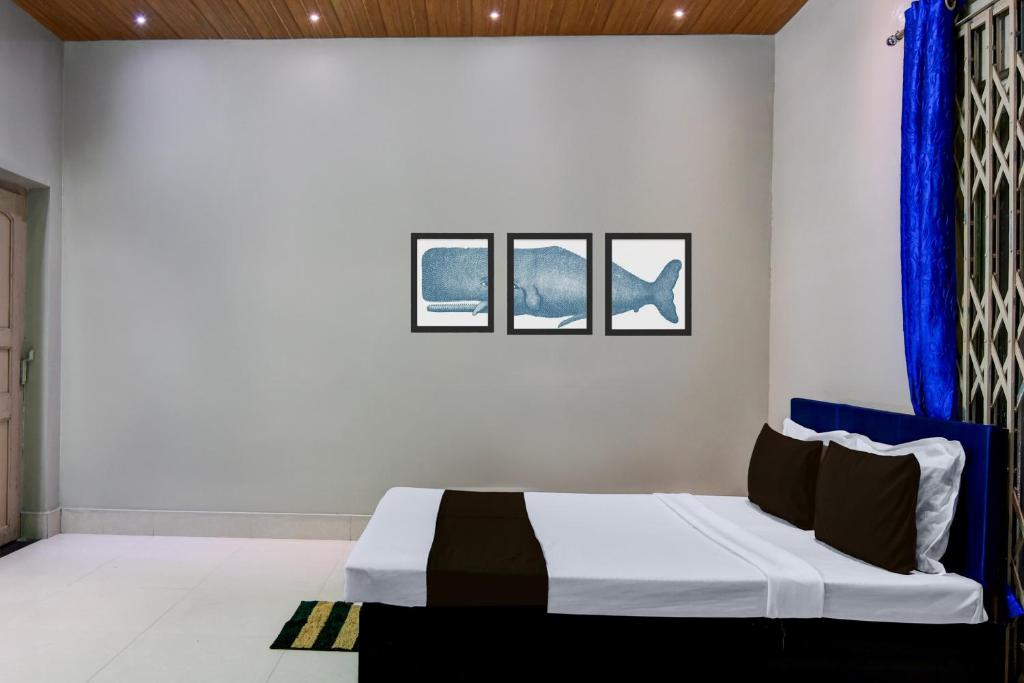 a bedroom with a bed and two windows at Hotel O Green Eco Space in Devanandapur