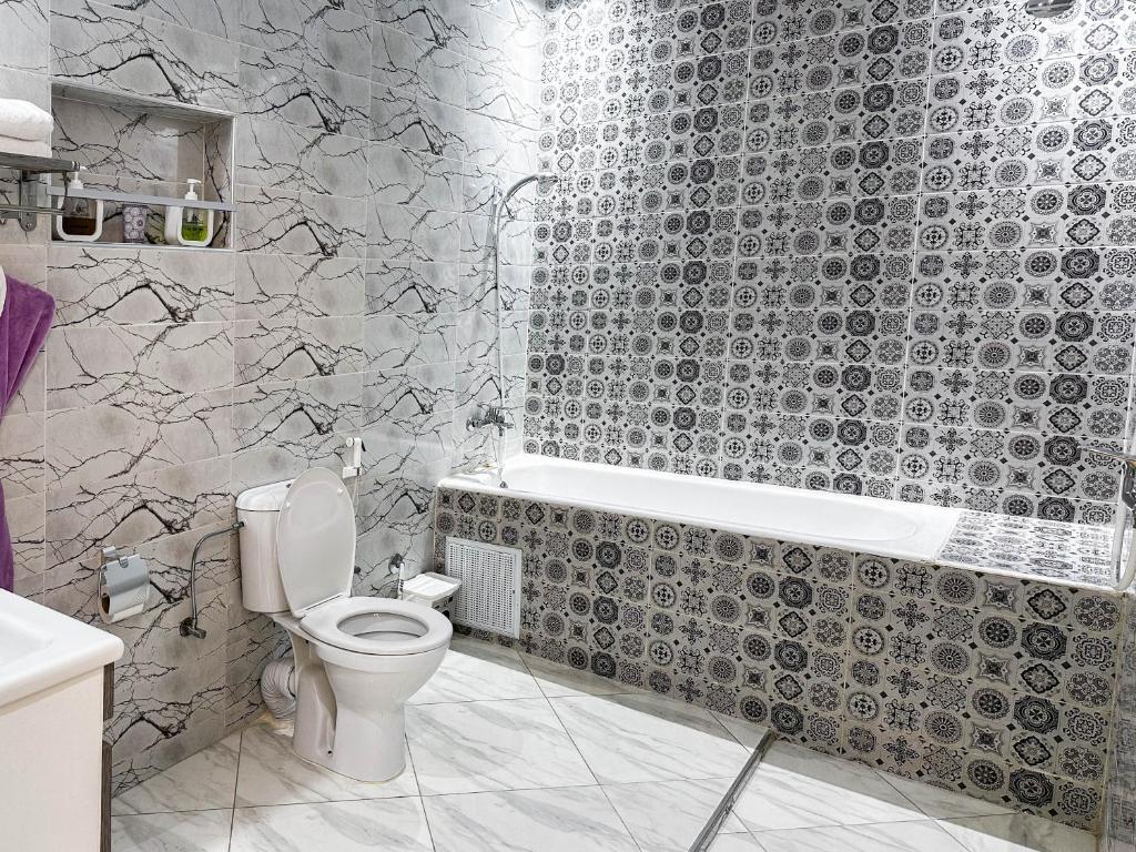 a bathroom with a toilet and a bath tub at Hotel America Apartments in Dakhla
