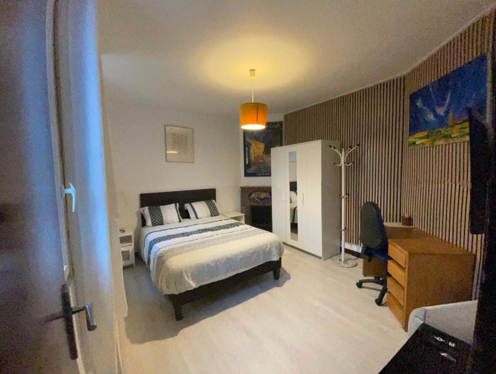 a bedroom with a bed and a desk in it at Studio cosy proche de Paris in Ermont