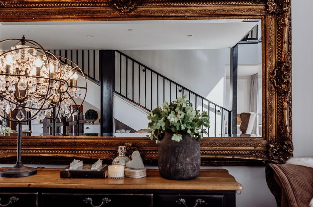 a vase of flowers on a table in front of a mirror at The Black Barn - Panoramic, Private & Luxury in Marsden