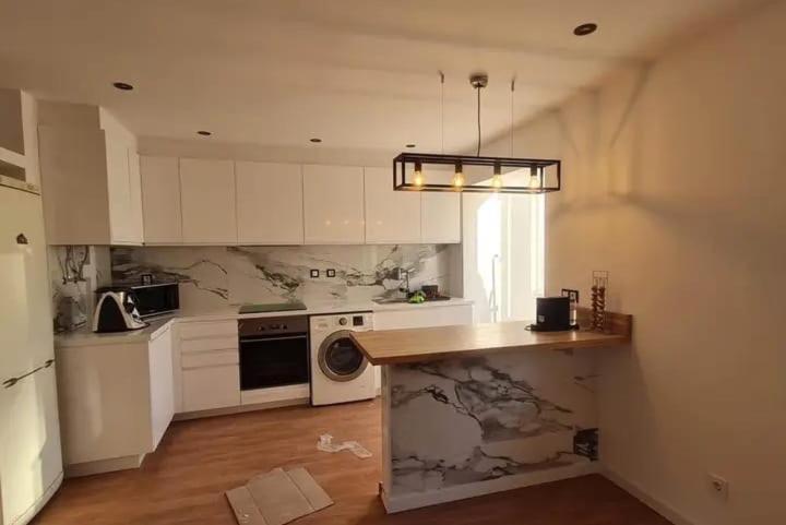 Una cocina con gabinetes blancos y encimera. en Casa Jones, en Lagos