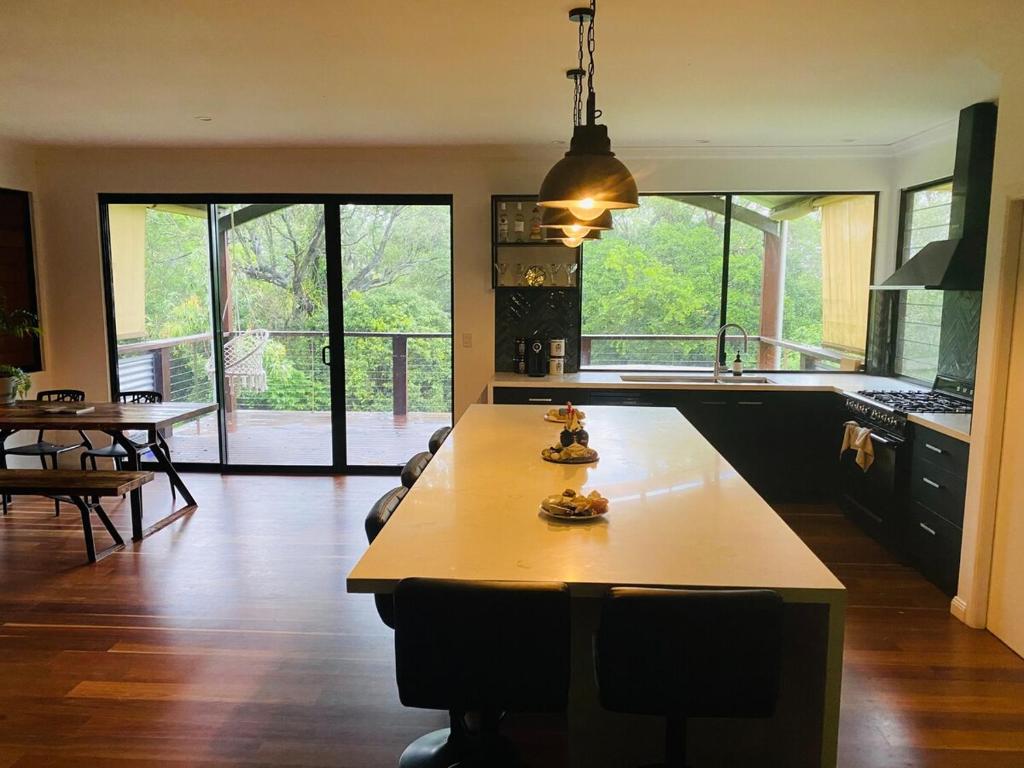 a large kitchen with a table and a large window at The Hinterland Spa & Moon Retreat in Boyland