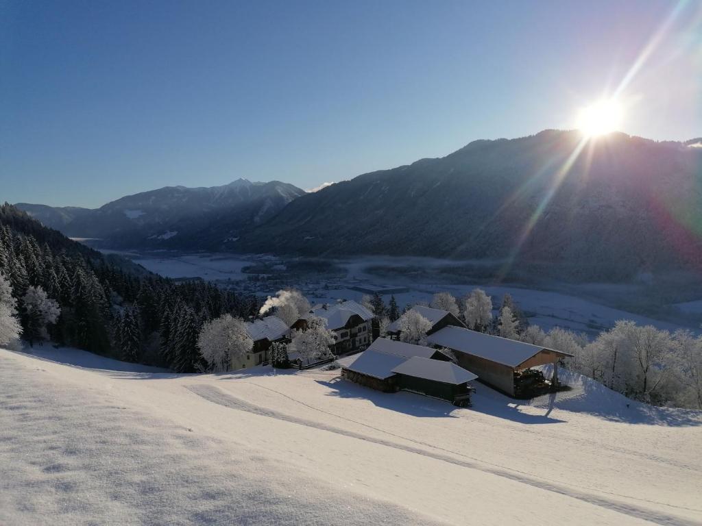 a snow covered mountain with the sun in the background at Waldpension Ranner 