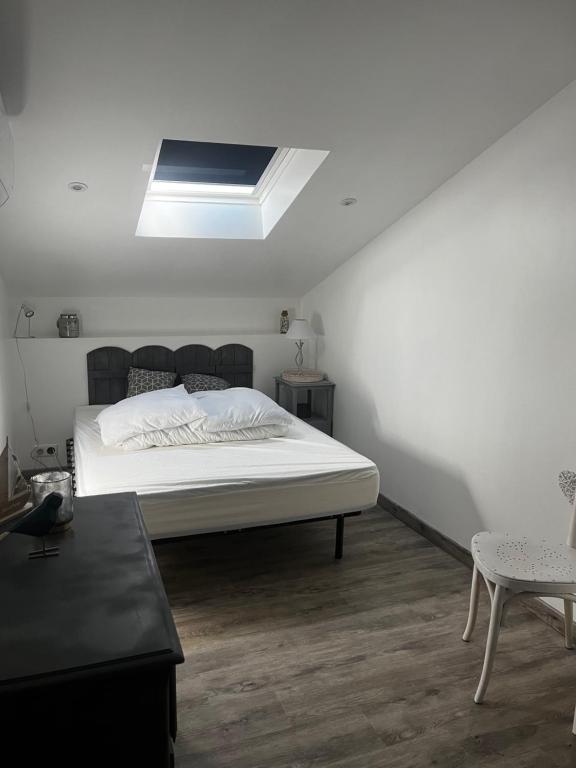 een slaapkamer met een groot bed en een dakraam bij Maison de vacances à Oléron classée 3 étoiles in Saint-Denis-dʼOléron