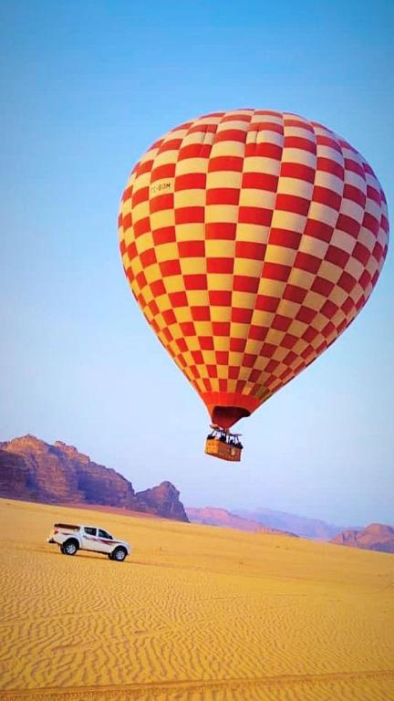 Un globo aerostático sobrevuela un coche en el desierto en وادي رم, en Wadi Rum
