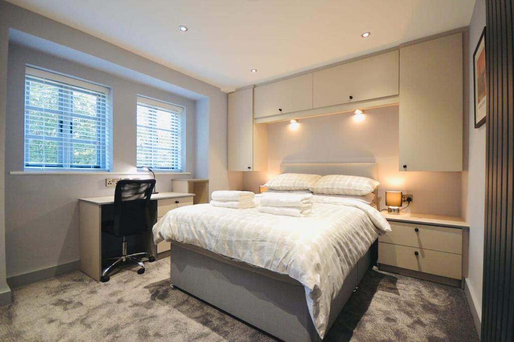 a bedroom with a bed with a desk and a chair at Luxury Two Bed Suite - Walk To Trentham Gardens! in Stoke on Trent
