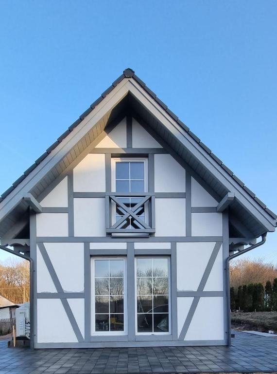 a white and black building with a window at Rodzinna Przystań in Łupawa
