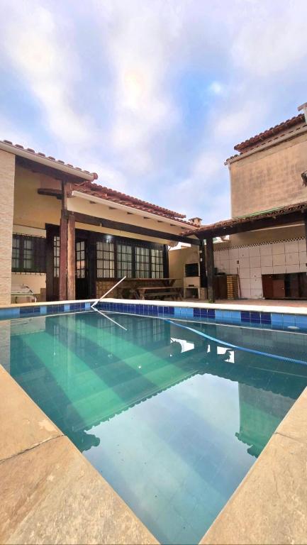 a swimming pool in front of a building at Casa com Piscina Peró in Cabo Frio