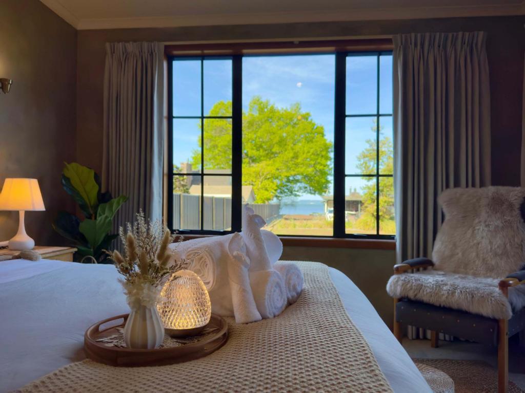 a bedroom with a bed and a large window at Stillwater Residence - Lakeview Serenity Retreat in Ngongotaha