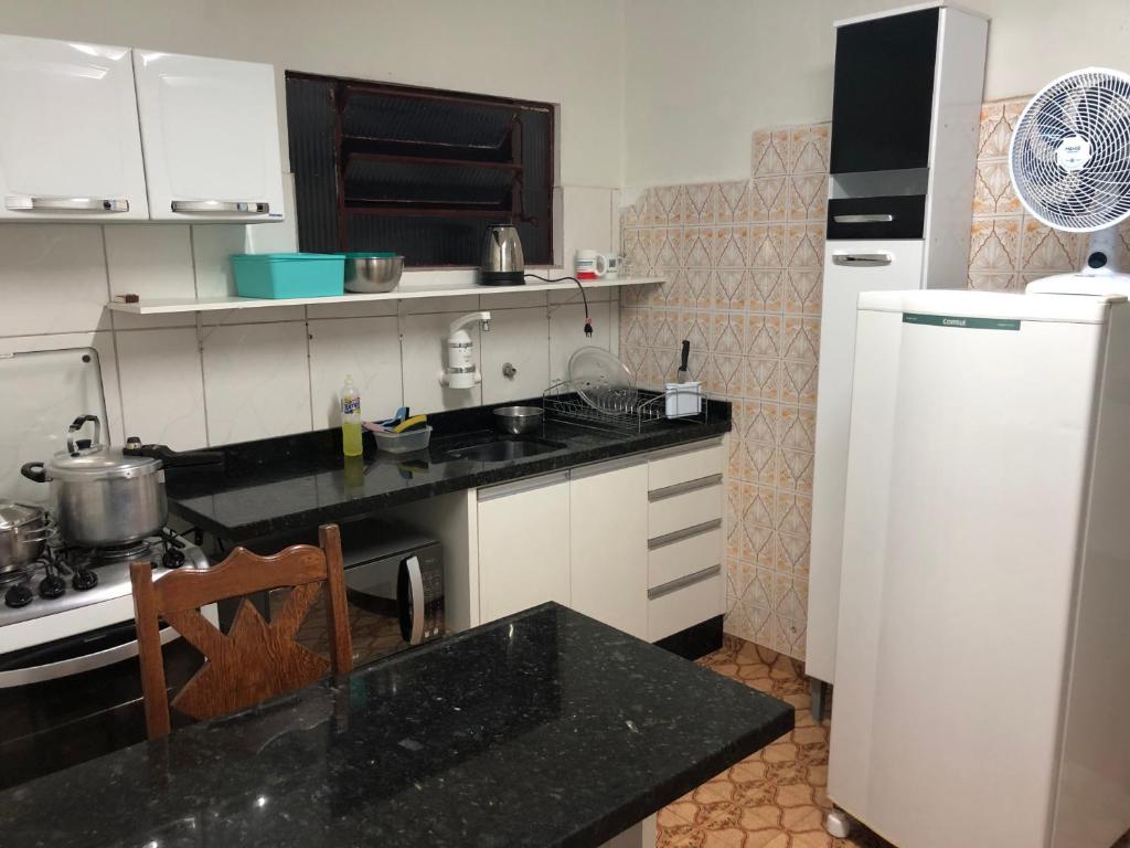 una cucina con frigorifero bianco e piano di lavoro nero di Casa para Estadia a Foz do Iguaçu