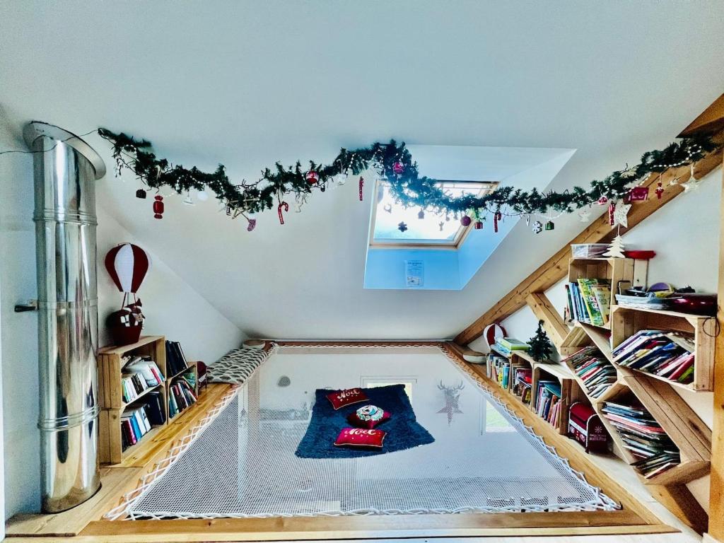 an attic room with a swimming pool in the ceiling at Gîte Le repaire du faon-4 étoiles-12 pers-filet mezzanine-lit cabane in Plainfaing