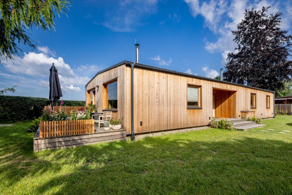 een klein houten huis in een tuin met een boom bij Chata Modřínka apartmány in Seč