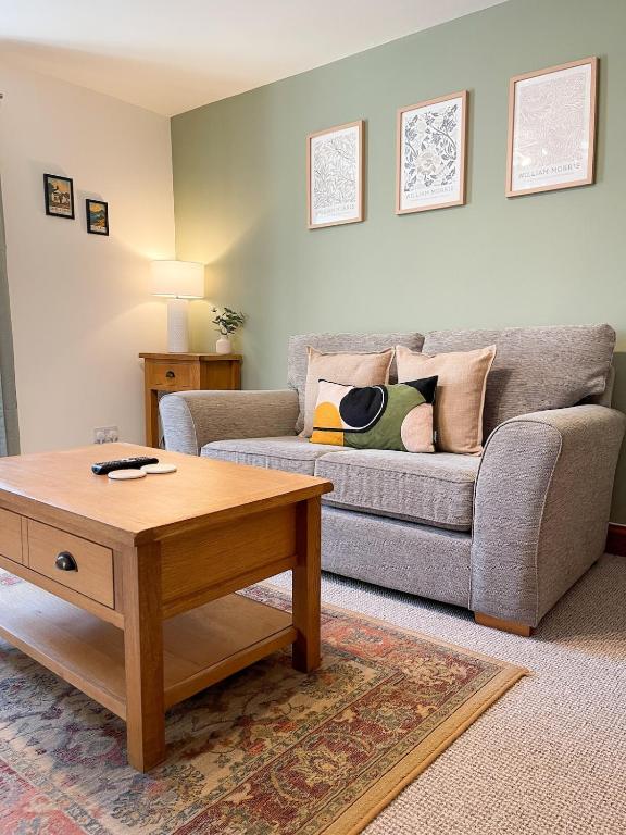 ein Wohnzimmer mit einer Couch und einem Couchtisch in der Unterkunft Hadrians Retreat, Cosy 1 Bed Flat - near M6 Jct45, A75, Gretna & Carlisle in Longtown