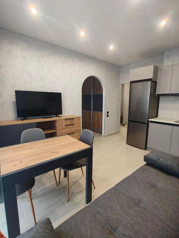 a living room with a table and a kitchen at New Suit Apartment in Hostomelʼ