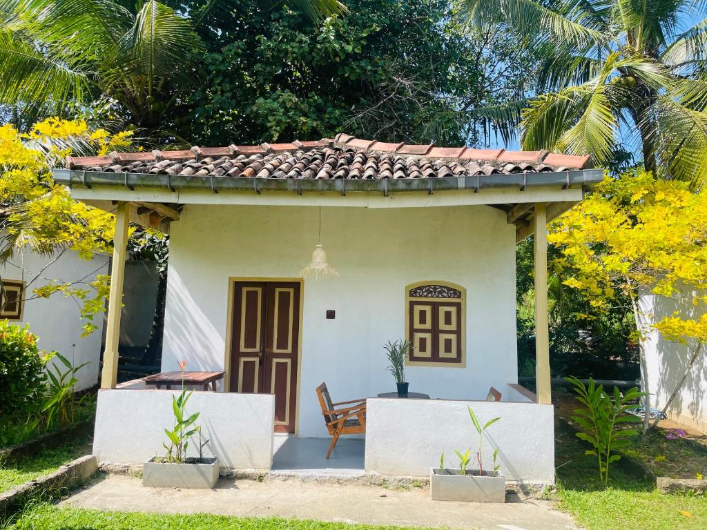 a small white house with a roof at Cabana Unawatuna in Unawatuna