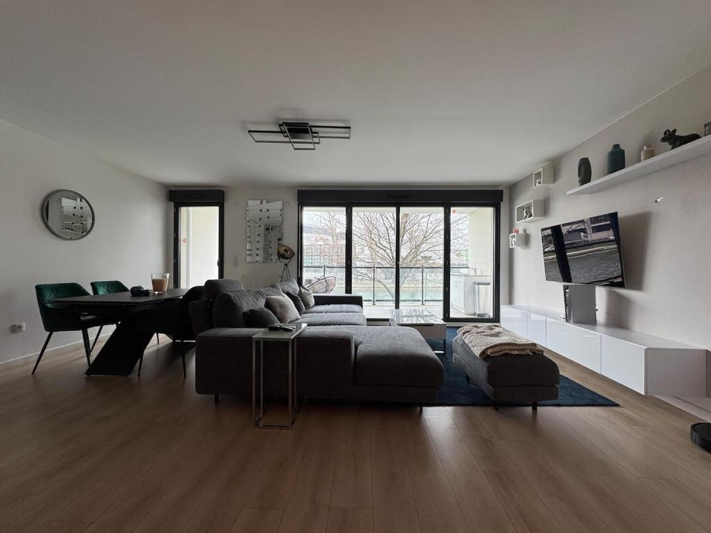 ein großes Wohnzimmer mit Couch und Tisch in der Unterkunft Quiet and Spacious 2BR And Salon Terrasse Parking in Saint-Denis
