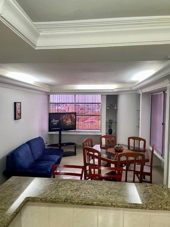 a living room with a blue couch and a table and chairs at Comfortable apartment, excellent location in Maracaibo