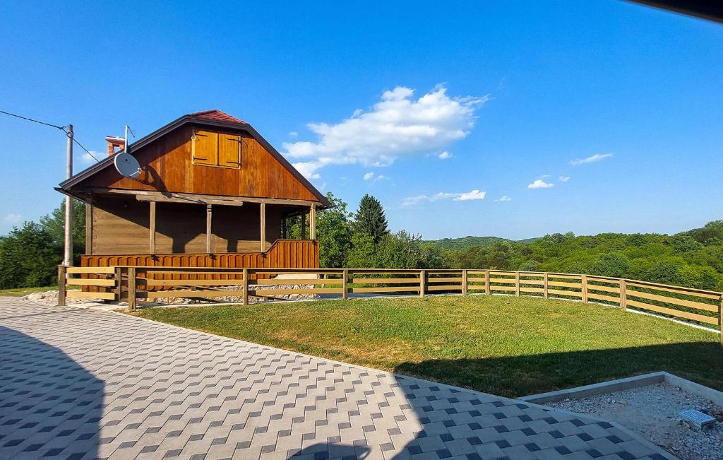 een klein houten huisje met een hek en gras bij 2 Bedroom Stunning Home In Karlovac in Zadoborje