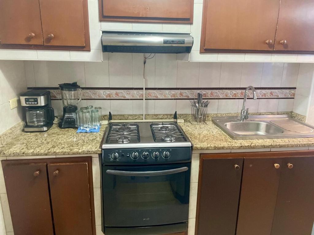 a kitchen with a stove and a sink at Comfortable apartment, excellent location in Maracaibo