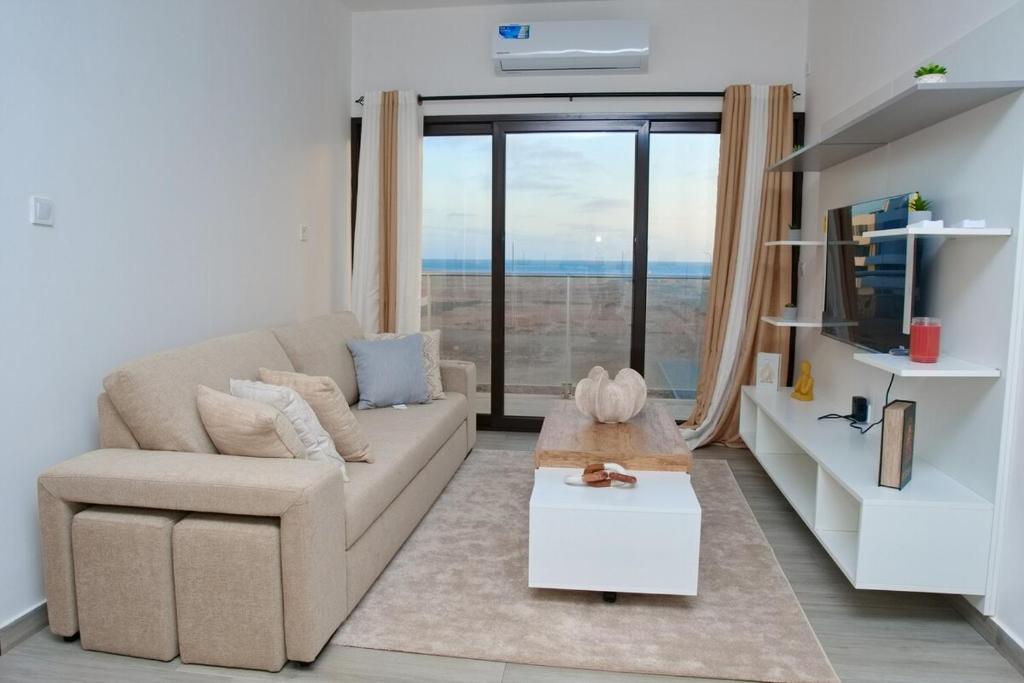 a living room with a couch and a large window at Comfort and Peace in Santa Maria