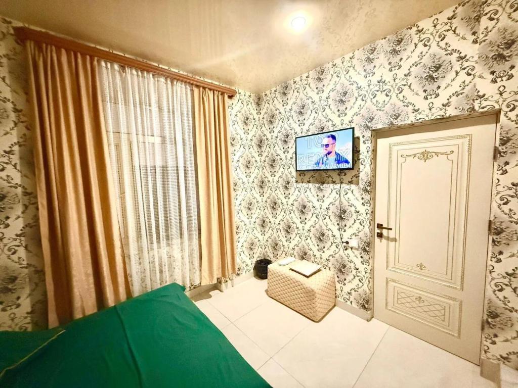 1 dormitorio con puerta y TV en la pared en Hostel, en Ereván