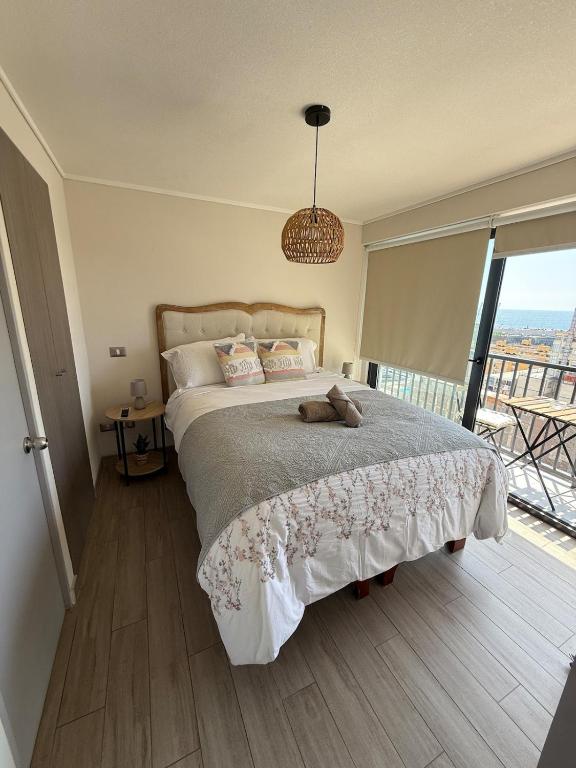 ein Schlafzimmer mit einem großen Bett und einem großen Fenster in der Unterkunft Acogedor Departamento en pleno centro de Antofagasta, hasta 4 personas, 1D 1B 1 sofá cama in Antofagasta