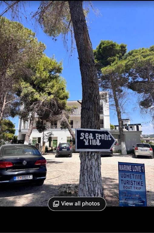 a sign on a tree in front of a car at Beach front villa 1 in Vlorë