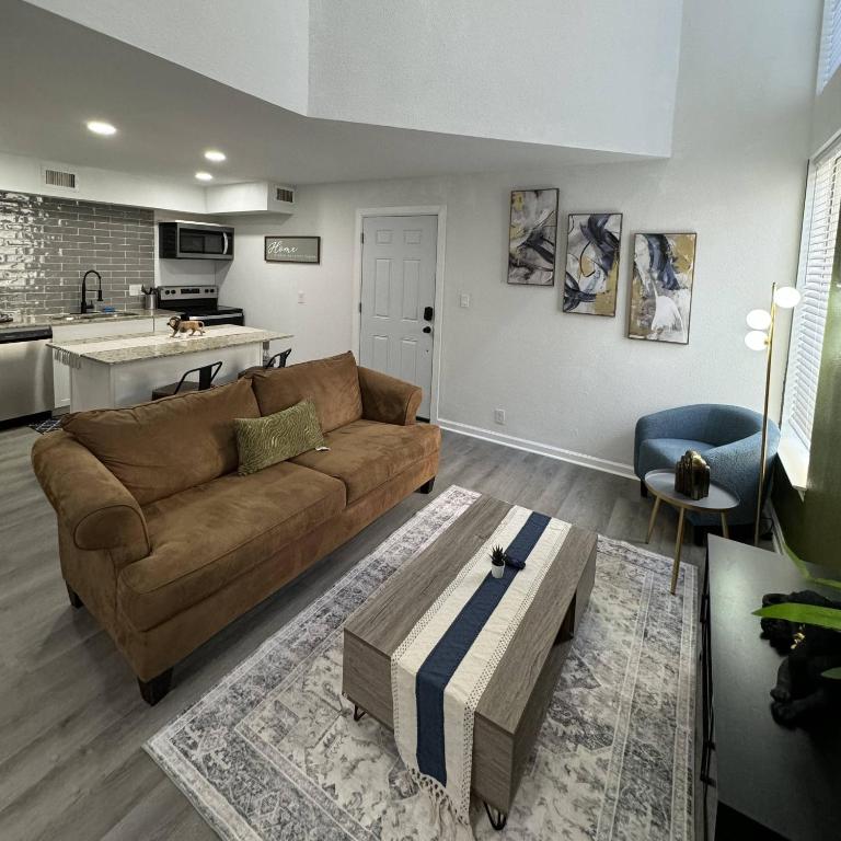een woonkamer met een bruine bank en een keuken bij 3BD DT Dallas l FIFA WORLD CUP READY l 5 Min from Love Field in Dallas