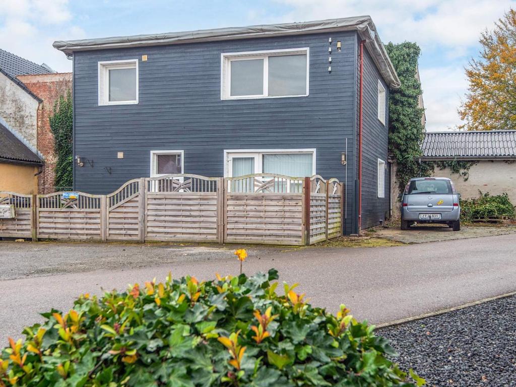 a blue house with a wooden fence in front of it at 4 person holiday home in Ansager-By Traum in Ansager