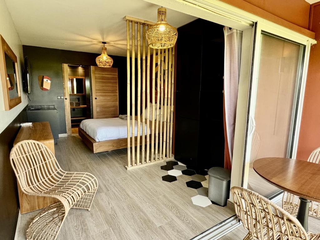 a bedroom with a bed and a table and chairs at Village Soleil in Îlet à Boissard