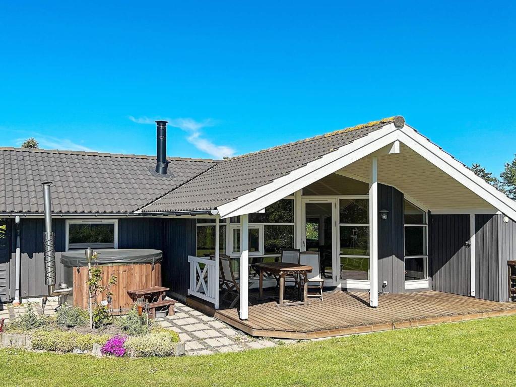 une maison avec une terrasse avec une table et un grill dans l'établissement 6 person holiday home in Nakskov-By Traum, à Nakskov