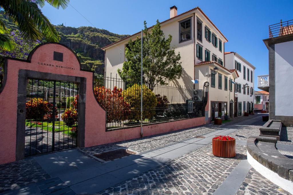 eine gepflasterte Straße mit einem Tor und Gebäuden in der Unterkunft Visconde Apartment in Ribeira Brava