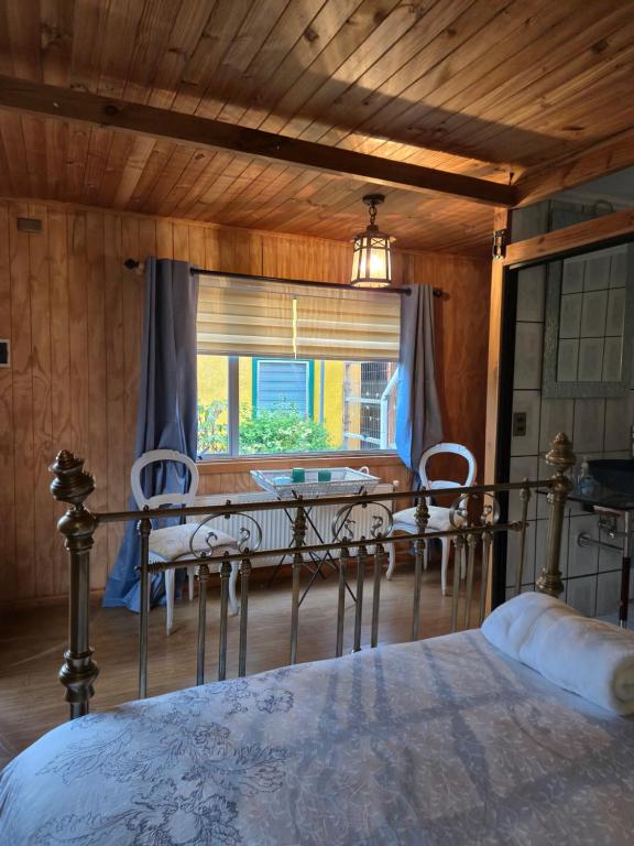a bedroom with a bed and a table and a window at Hotel de los Castillos in Puerto Natales