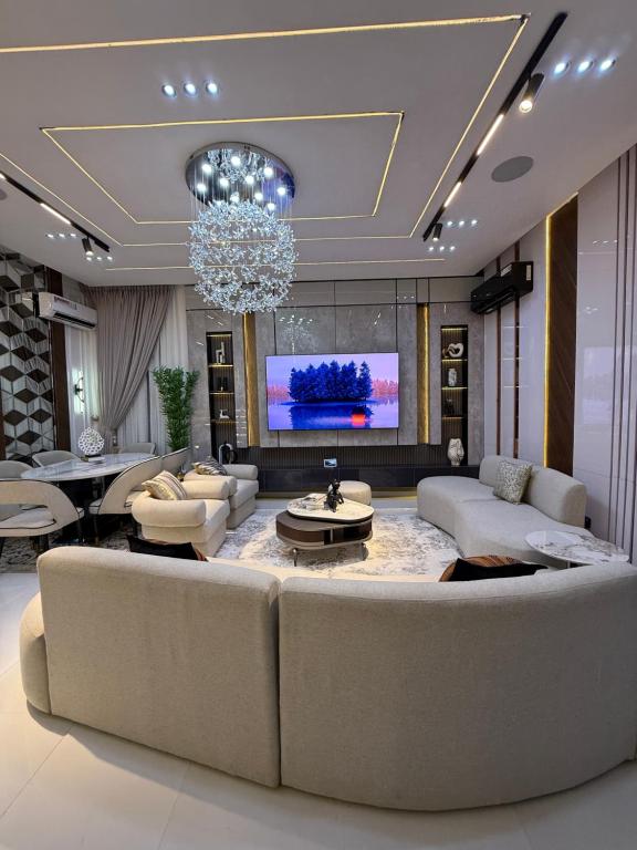 sala de estar con sofá grande y lámpara de araña en ZELE homes, en Aja