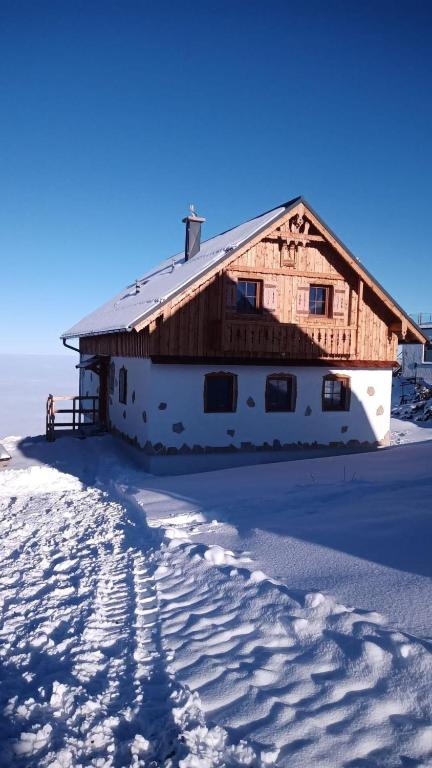 a barn in the snow with footprints in the snow at Erlakogelhütte am Feuerkogel in Ebensee