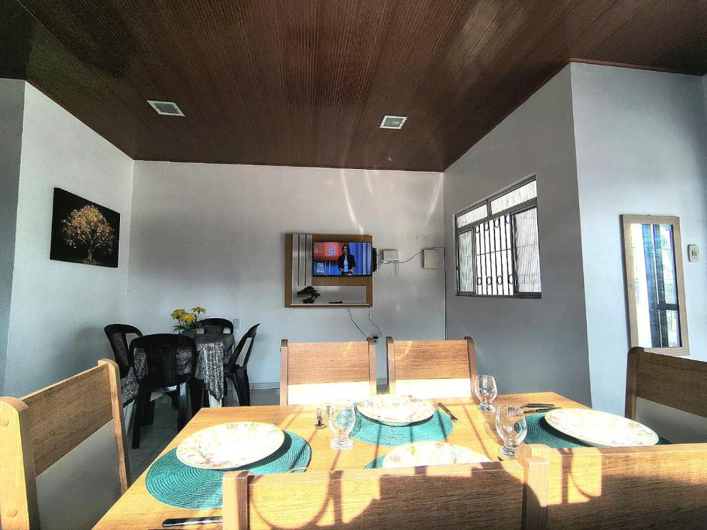 ein Esszimmer mit einem Holztisch, auf dem Gläser stehen in der Unterkunft Casa Altos COP30, Next to the Hangar in Belém