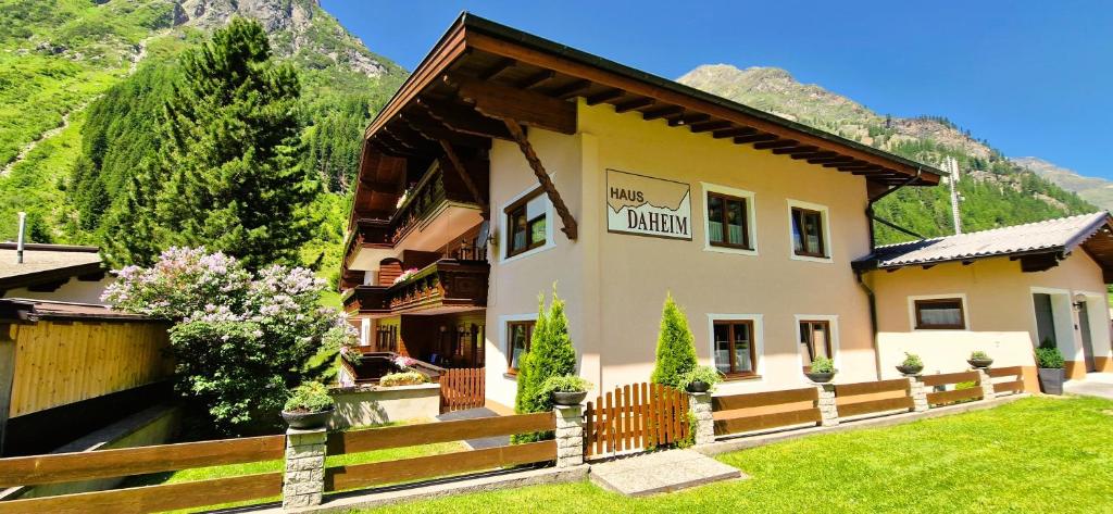a large house with a fence and a yard at Haus Daheim in Sankt Leonhard im Pitztal