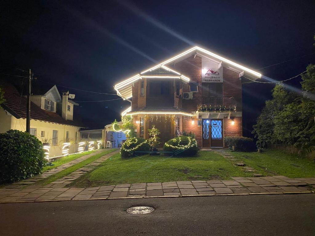 a house with lights on the front of it at night at Pousada dos Pássaros in Gramado
