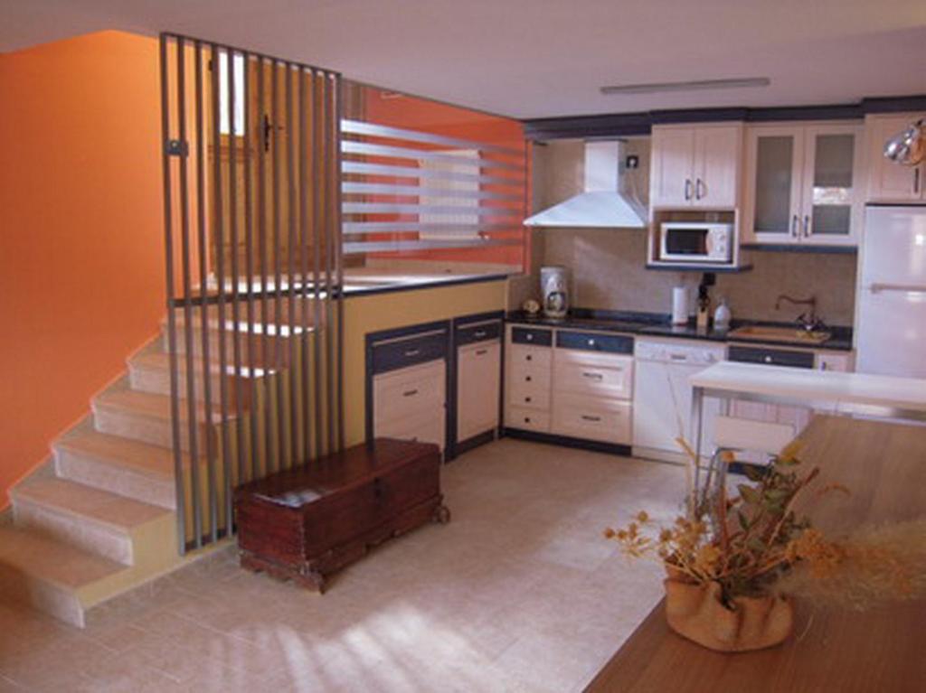 una cocina con una escalera que conduce a una cocina en Casa Rural Apartamento El Chaveto, en Herreros